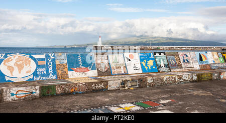 Immagine del porto di approdo a Horta, colorati dipinti del marinaio arrivi, faro e alla vicina isola di Pico in background Foto Stock