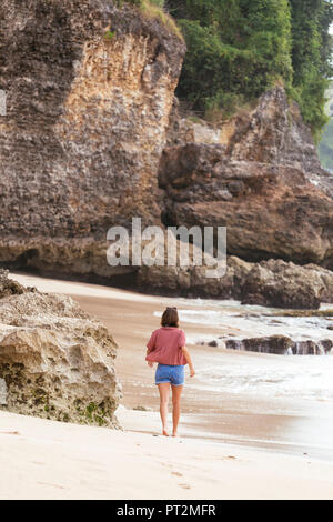 Indonesia, Bali, giovane donna in spiaggia, vista posteriore Foto Stock