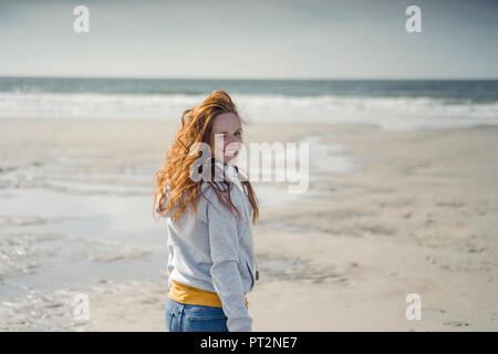 Redheaded donna relax sulla spiaggia, ridendo Foto Stock