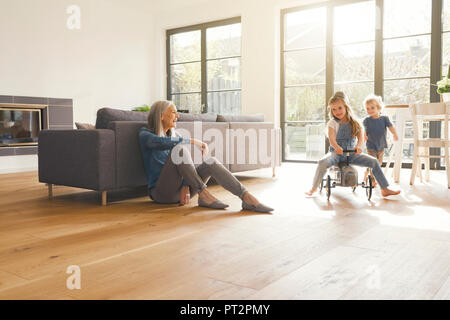 Nonni osservando la nonna, giocando in soggiorno Foto Stock