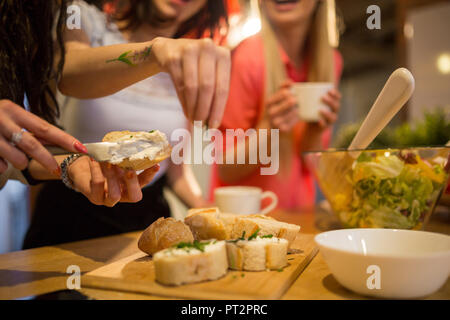 Close-up di amici di sesso femminile la preparazione della cena insieme Foto Stock