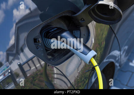 La ricarica di un auto elettrica Foto Stock