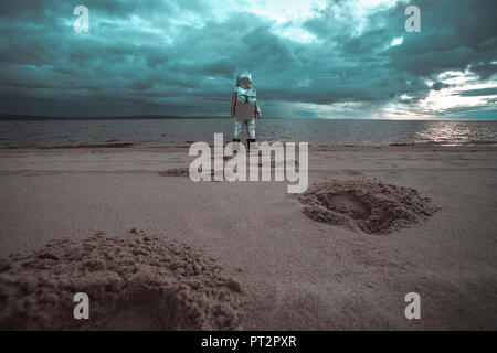 Lonely spaceman guardando il lago sul pianeta anonimi Foto Stock