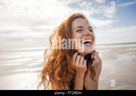 Ritratto di una donna redheaded, ridevano allegramente sulla spiaggia Foto Stock