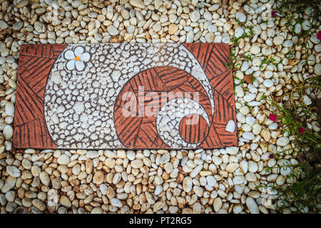 Vintage a piedi modo tile con ciottoli bianchi nel giardino. Blocco di pietra piastrella per il sentiero sulla ghiaia bianca di massa. Foto Stock