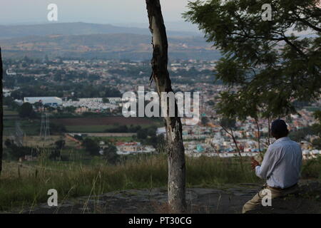 Señor apreciando el paisaje desde el Cerro de la reina en Tonala, vista panoramica de la barranca de Huentitan en onu atardecer de la ciudad Foto Stock