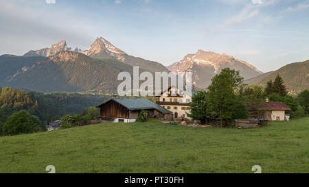 Montagna del massiccio con il Watzmann e Hochkalter, davanti prato alpino e farm, Parco Nazionale di Berchtesgaden, Baviera, Germania Foto Stock