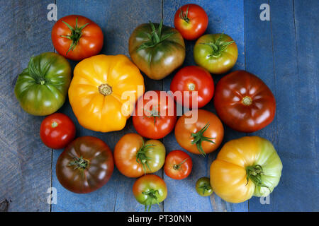 Pomodori deliziosi colori diversi sul vecchio legno blu Foto Stock