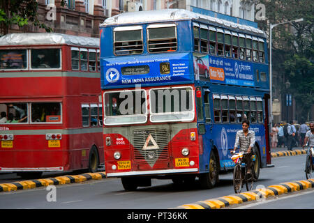 Un vecchio ben utilizzati double decker 2 Storia Leyland Bus passa alcuni ciclisti sulle strade trafficate di Mumbai, India. Foto Stock