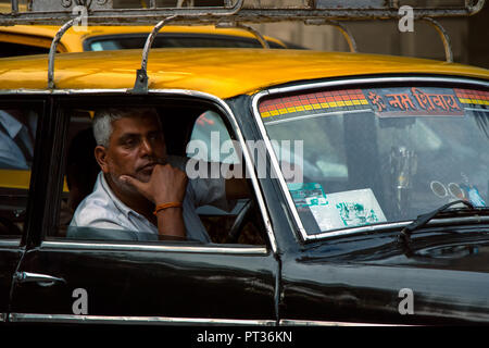 Un onu indiano rasate di taxi sembra pensively fuori delle sue vetture windows mentre seduto in un altro traffico in Mumbai, India. Foto Stock