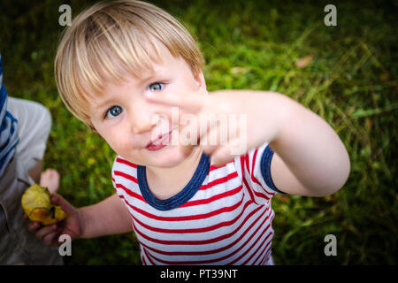 Il Toddler, due-anno-vecchio con la rossa e bianca a strisce tee, sfrontato, di fronte alla fotocamera Foto Stock