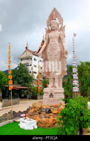 Enorme statua di standing Signore Buddha accanto ai cinque bianco Buddha seduto al Wat Prathat, son Pha Kaew, in Khao Kor, Phetchabun, Thailandia. Foto Stock