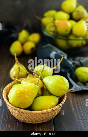Fresco giardino pere nel cesto su legno scuro, tabella Foto Stock