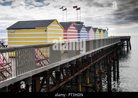 Cabine sulla spiaggia, sul molo di Hastings Foto Stock