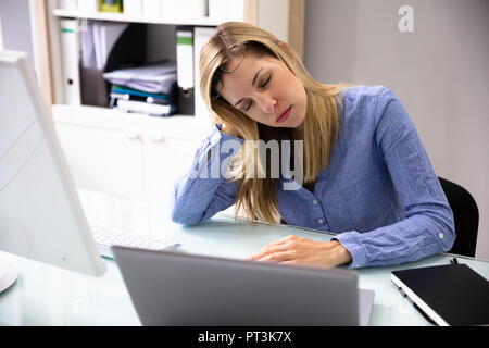 Foto di bella giovane imprenditrice dormire in ufficio Foto Stock