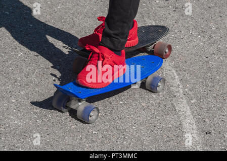 Little Boy urbano con un penny skateboard. Il bambino impara a cavalcare un penny board Foto Stock