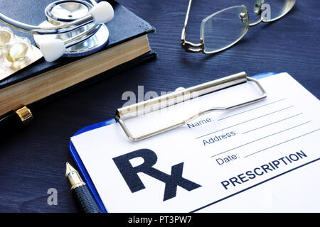 Health care concetto. Modulo di prescrizione e pillole su una scrivania. Foto Stock