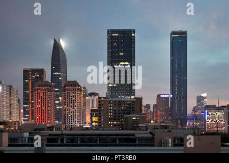 Edifici ad alta nel quartiere di Futian accesa al crepuscolo. Shenzhen, Provincia del Guangdong, Cina. Foto Stock