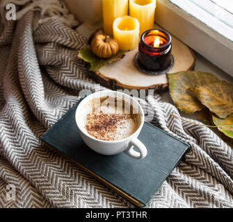 Autunno ancora in vita con tazza di caffè e candele, accogliente rientrano i dettagli interni con coperta e la tazza di caffè o una cioccolata calda Foto Stock