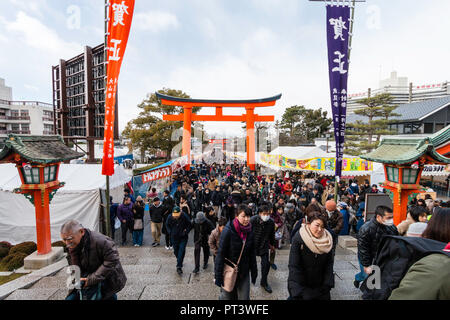 Giapponese Anno nuovo, Shogatsu. La gente camminare l approccio al Fushimi Inari santuario a Kyoto per la loro prima visita del nuovo anno, Hatsumode. Foto Stock