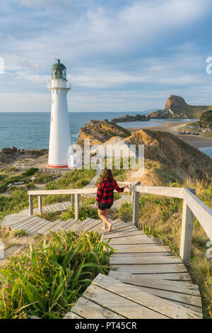 Donna Scendendo il sentiero verso Castlepoint faro, Castlepoint, Wairarapa regione, Isola del nord, Nuova Zelanda, Foto Stock