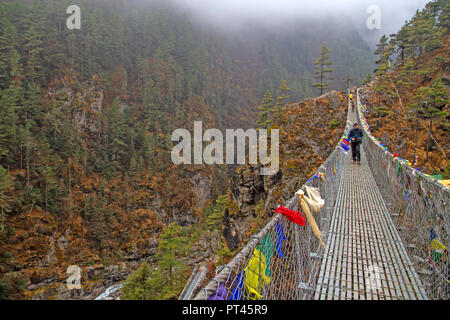 Trekker su un ponte di sospensione al di sopra del Dudh Kosi al di sotto di Namche Bazaar Foto Stock
