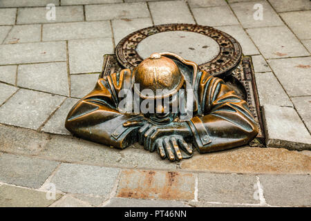 La scultura in bronzo di un uomo in un tombino chiamato 'man sul luogo di lavoro " a Bratislava, in Slovacchia Foto Stock