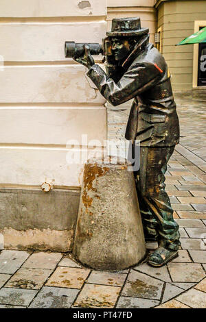 Paparazzi fotografo statua in piedi su un angolo della Radnicna e Laurinska street a Bratislava, in Slovacchia Foto Stock