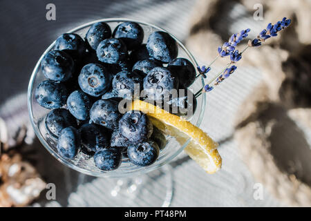 Cocktail con bluberriy nella coppetta Martini in bright tavolo in legno Foto Stock
