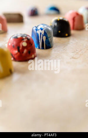 Blue cioccolato artigianale bonbon in una fila di quelli colorati. Copia dello spazio sul fondo. Foto Stock