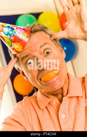 Uomo maturo clowning presso la festa di compleanno di un bambino in, STATI UNITI D'AMERICA Foto Stock