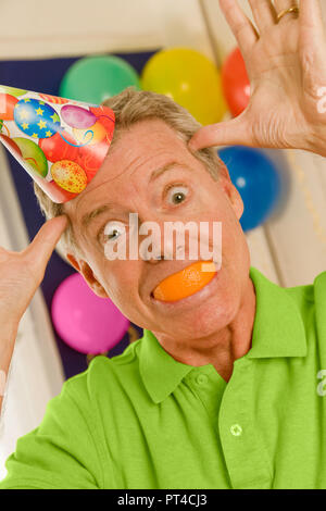 Uomo maturo clowning presso la festa di compleanno di un bambino in, STATI UNITI D'AMERICA Foto Stock