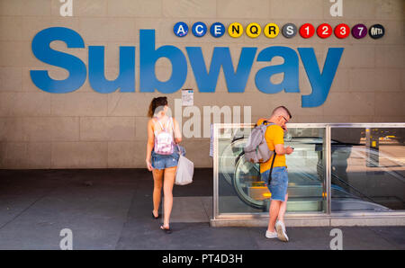 Una giovane donna entra nell'ingresso della metropolitana Di Times Square nel centro di Manhattan, New York Foto Stock