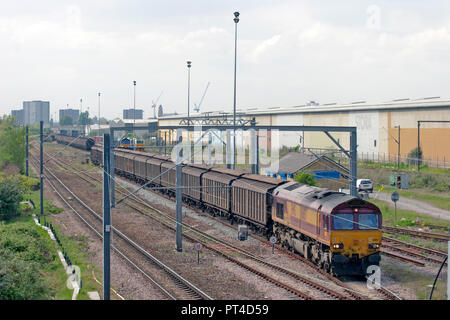 Una classe 66 locomotiva diesel numero 66157 la derivazione di un rastrello di carri in corsia di ondulazione di cantiere nella zona est di Londra. 66157 la derivazione di un molto tardi in esecuzione 6L59 da Foto Stock