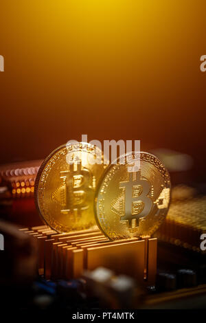 Bitcoins e nuovo denaro virtuale concetto, bitcoins contro lo sfondo della scheda madre Foto Stock