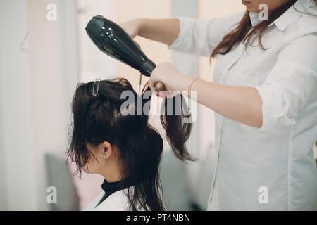 Bruna ragazza al parrucchiere di fare lo styling Foto Stock