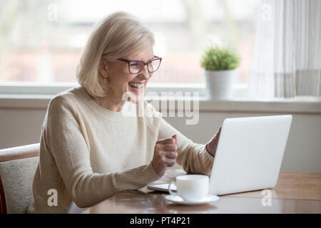 Felice Coppia di mezza età anziana donna business vincitore eccitato dalla lettura buona novella guardando laptop, lieto senior vecchia signora guardando celebrando onl Foto Stock