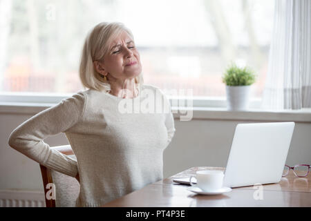 Sconvolto coppia donna di mezza età si sente dolore alla schiena massaggiare muscoli, triste senior vecchia signora soffre di bassa-schiena dolore lombare in seduta errato Foto Stock