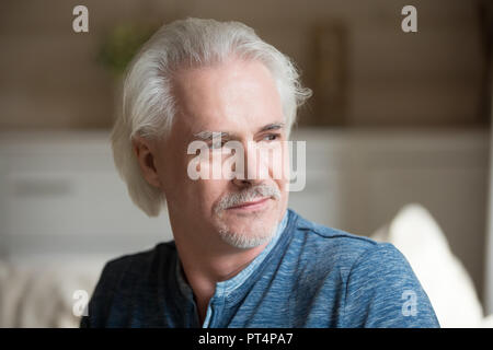Riflessivo senior uomo maturo che guarda lontano sognando di felice futu Foto Stock