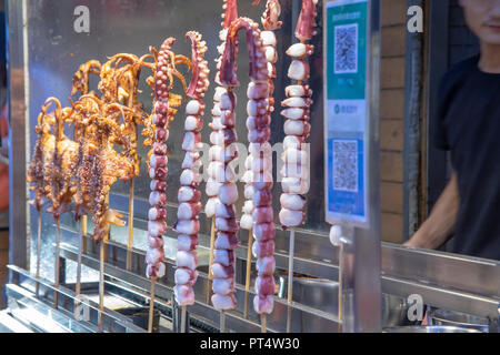 I calamari e i polipetti delicatezze da venditori ambulanti in Xi'an, Cina quartiere musulmano mercato all'aperto. Foto Stock