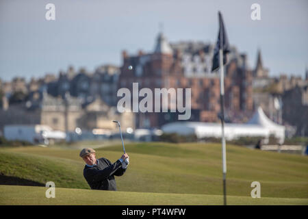 Attore Hugh Grant gioca da il lato verde di bunker in occasione del quindicesimo foro durante il giorno tre di Alfred Dunhill Links Championship presso la Old Course di St Andrews. Foto Stock