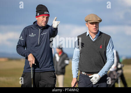 Attore Hugh Grant prende la direzione dalla sua riproduzione compagno David Howell al XVI foro durante il giorno tre di Alfred Dunhill Links Championship presso la Old Course di St Andrews. Foto Stock