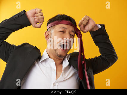 Ubriaco asian guy sbadigli colore di sfondo Foto Stock