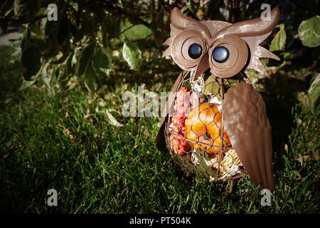 Un marrone costruito in metallo contenente il gufo caduta oggetti a tema. Foto Stock