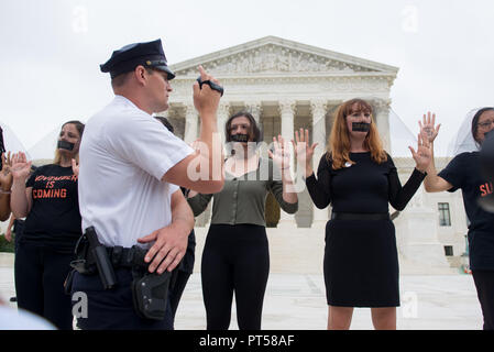 Washington, DC, Stati Uniti d'America. 6 Ottobre, 2018. Un funzionario di polizia film manifestanti con una mano sulla sua pistola al di fuori degli STATI UNITI La Corte suprema. Centinaia di manifestanti radunati fuori la Corte suprema e il Campidoglio mentre il Senato ha votato per confermare il giudice Brett Kavanaugh alla Corte Suprema. Credito: Erin Scott/ZUMA filo/Alamy Live News Foto Stock