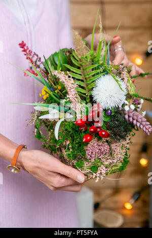 Disposizione del fiore nelle mani di un fioraio in fase di completamento Foto Stock