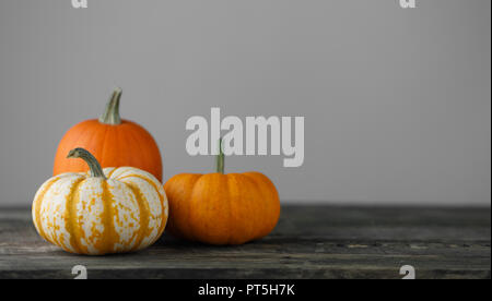 Tre le zucche sul tavolo di legno su sfondo grigio , concetto di Halloween Foto Stock