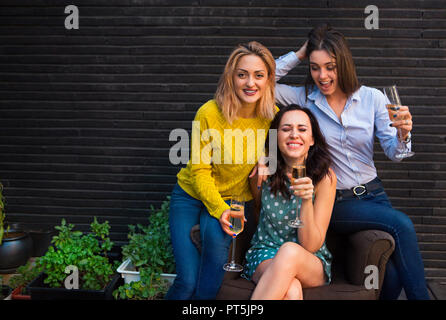 Un gruppo di ragazze che partying con flauti con vino frizzante divertirsi sulla parte Foto Stock