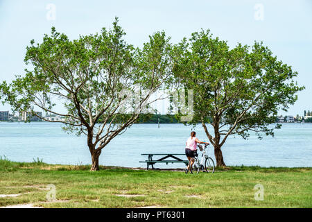 San Pietroburgo Florida, Bay Pines, War Veterans Memorial Park, Boca Ciega Bay, tavolo da picnic, donne donne donna, bicicletta bicicletta bicicletta bicicletta bicicletta equitazione bik Foto Stock