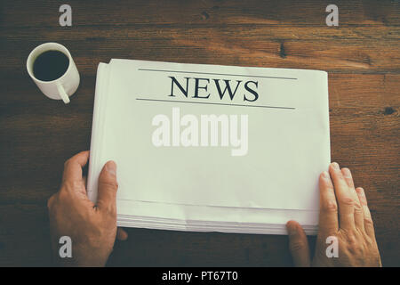Top visualizza immagine dei maschi di mano azienda quotidiano vuoto con lo spazio vuoto per aggiungere notizie o testo. in stile retrò immagine Foto Stock